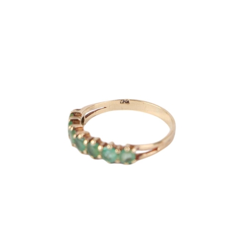 776 - A 9ct gold seven-stone emerald half eternity ring, approx UK size L, 1.3g.