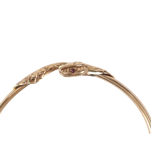 784 - A 9ct gold snake torc bangle with ruby set eyes, 10g.