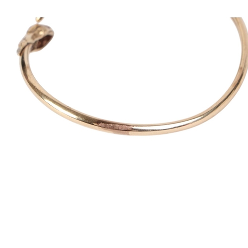 784 - A 9ct gold snake torc bangle with ruby set eyes, 10g.