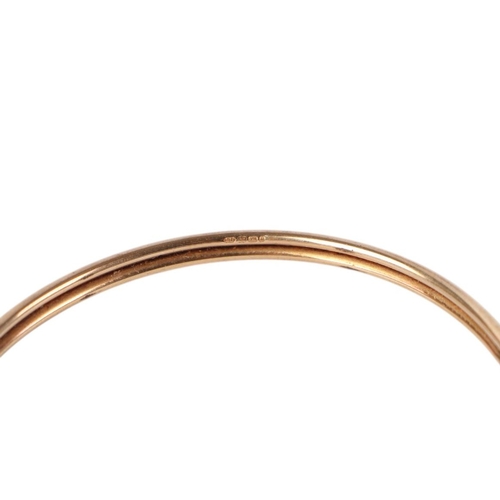 787 - A 9ct gold torc bangle with heart terminals, 6cms diameter, 3.6g.