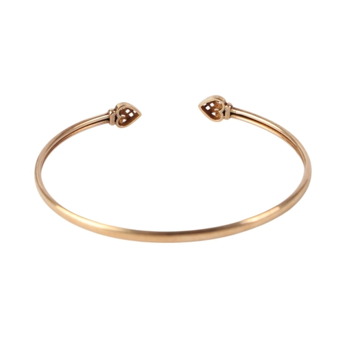 787 - A 9ct gold torc bangle with heart terminals, 6cms diameter, 3.6g.