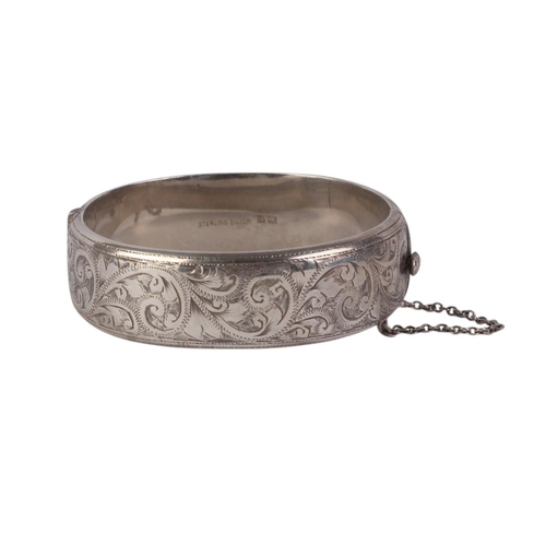 791 - A sterling silver hinged bangle with engraved decoration, 28g.