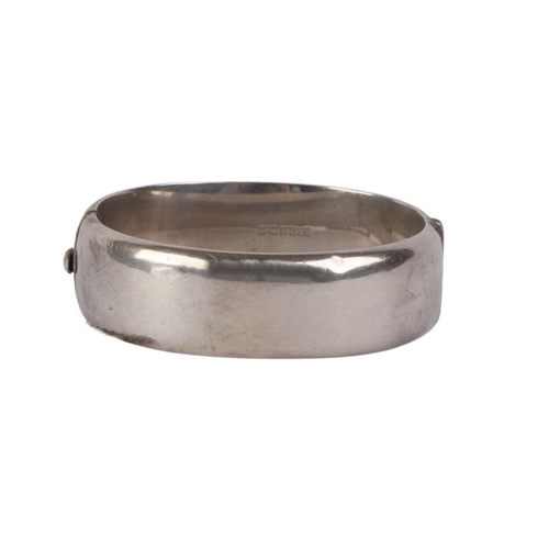 791 - A sterling silver hinged bangle with engraved decoration, 28g.