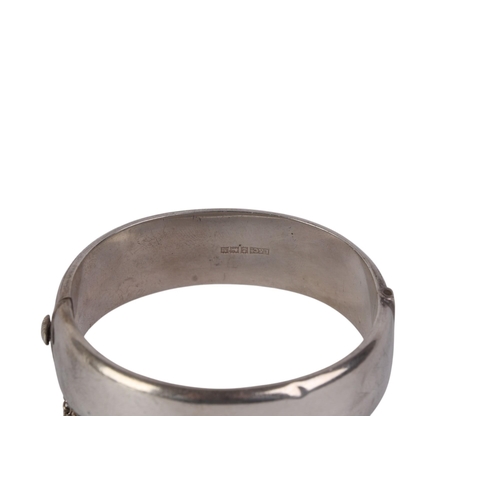 791 - A sterling silver hinged bangle with engraved decoration, 28g.