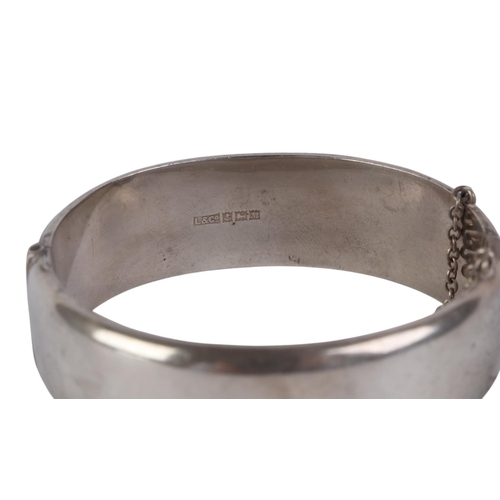 791 - A sterling silver hinged bangle with engraved decoration, 28g.