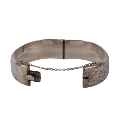 791 - A sterling silver hinged bangle with engraved decoration, 28g.