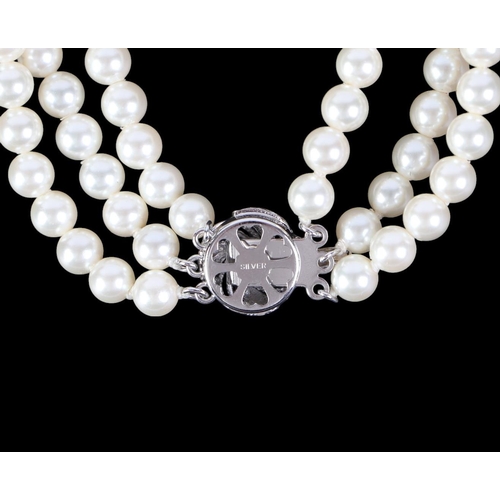 796 - A three-strand pearl necklace with silver clasp; together with a matching bracelet (2).