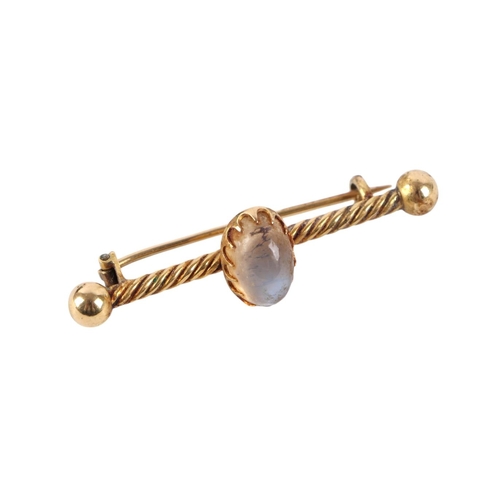 833 - A yellow metal bar brooch set with an oval moonstone cabochon, stamped '20', 4.5cms wide, 5.3g.