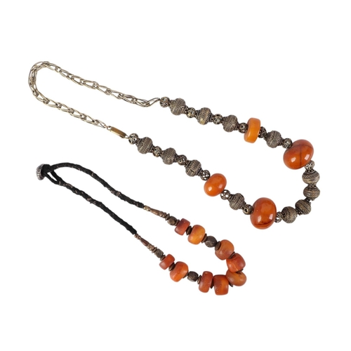 862 - A Moroccan amber bead necklace; together with a silver coloured metal and amber bead necklace (2).