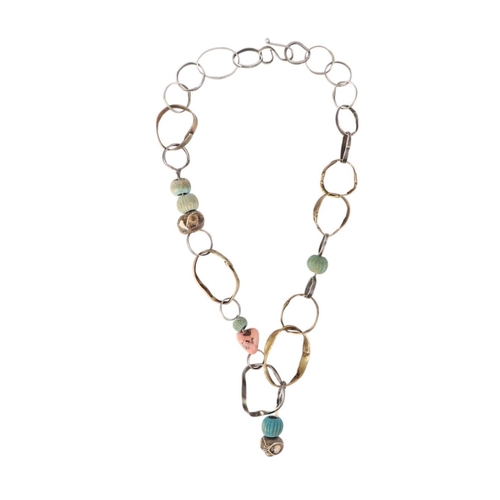 866 - An unusual design necklace made from white metal and brass rings interspersed with Roman beads.