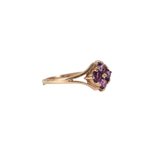 875 - A 9ct gold dess ring set with four purple stones, approx UK size N, 1.3g.