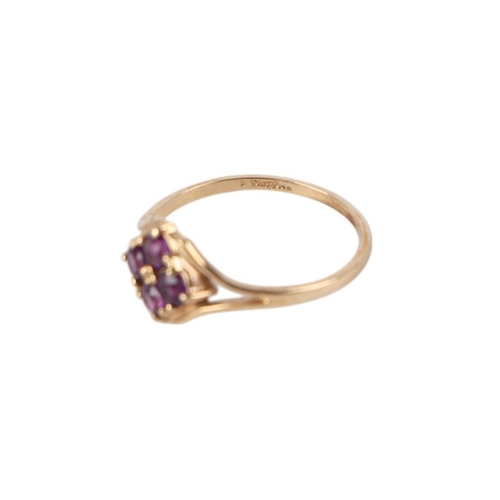 875 - A 9ct gold dess ring set with four purple stones, approx UK size N, 1.3g.