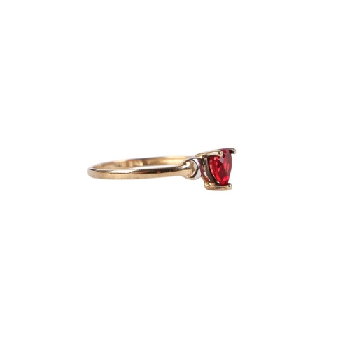 884 - A 9ct gold dress ring set with a heart shaped red stone, approx UK size L, 0.9g.