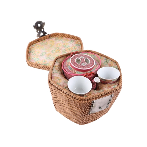 910 - A Chinese Republic style famille rose porcelain tea set contained within a wicker warming basket.Con... 