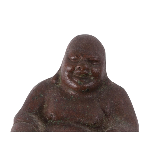 925 - A Chinese hollow cast figure of a seated Buddha, on a hardwood stand, 11cms high.