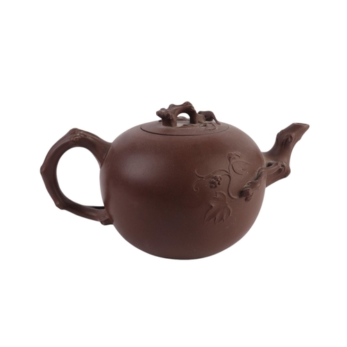 946 - A Chinese Yixing pottery teapot, 11cms high; together with two Chinese Yixing miniature teapots (3).