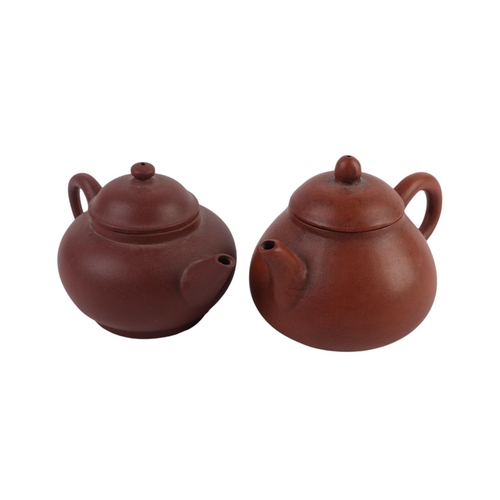 946 - A Chinese Yixing pottery teapot, 11cms high; together with two Chinese Yixing miniature teapots (3).