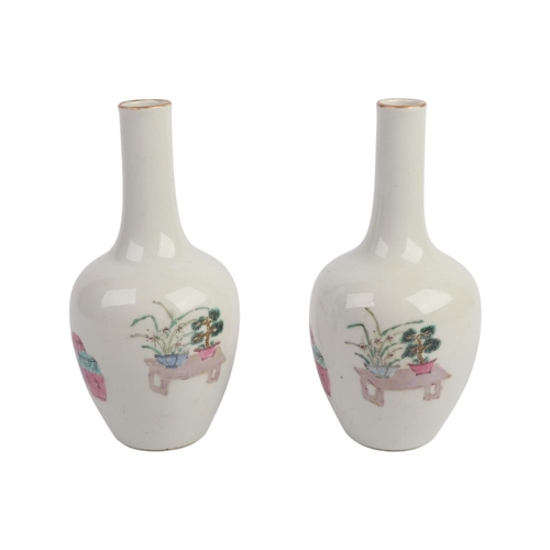 956 - A pair of Chinese famille rose bottle vases decorated with figures, 17cms high.