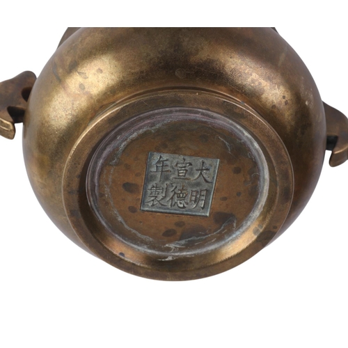 964 - A Chinese two-handled bronze censer with six character mark to the underside, 13cms diameter.