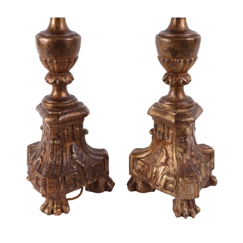 997 - A pair of ornate giltwood lamps on three paw feet (later converted to electricity), 64cms high exclu... 