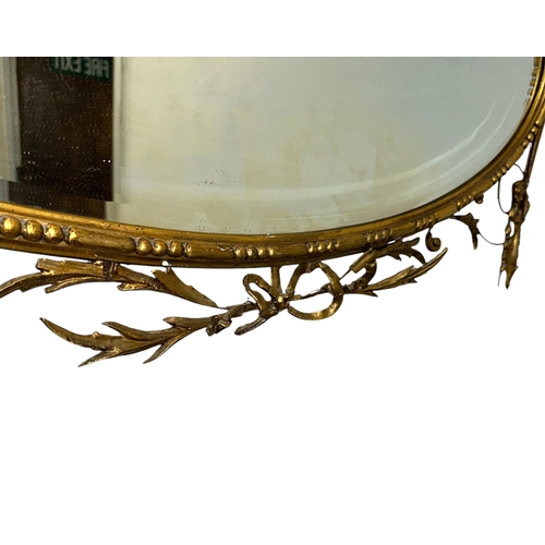 1065 - A 19th century oval carved giltwood wall mirror decorated with flowers and acanthus leaves, overall ... 