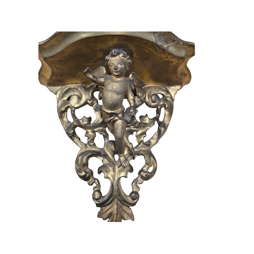 569 - A pair of 19th century carved giltwood shelf brackets with winged cherub decoration, 24cms high (2).