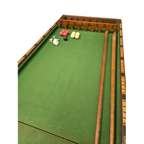 509 - A Victorian bar billiards game by A W Gamage, London, with green baize; lined playing surface, cues ... 