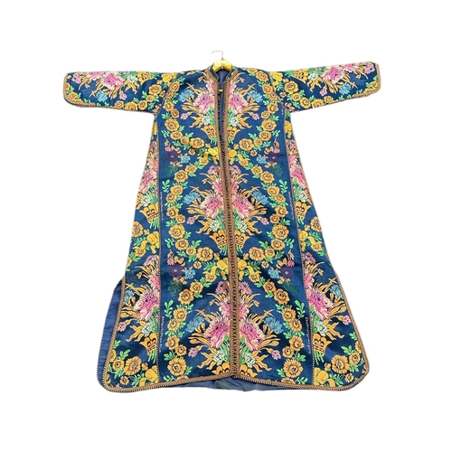 163 - A Moroccan embroidered kaftan decorated with flowers on a blue ground, signed.