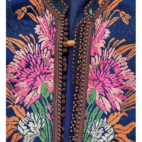 163 - A Moroccan embroidered kaftan decorated with flowers on a blue ground, signed.