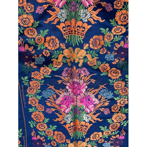 163 - A Moroccan embroidered kaftan decorated with flowers on a blue ground, signed.