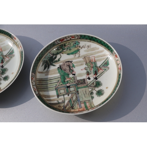 962 - A pair of Chinese famille vert saucer dishes decorated with figures on a terrace, 13.5cms diameter (... 