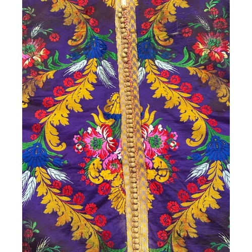 165 - A Moroccan embroidered kaftan decorated with flowers on a purple ground.