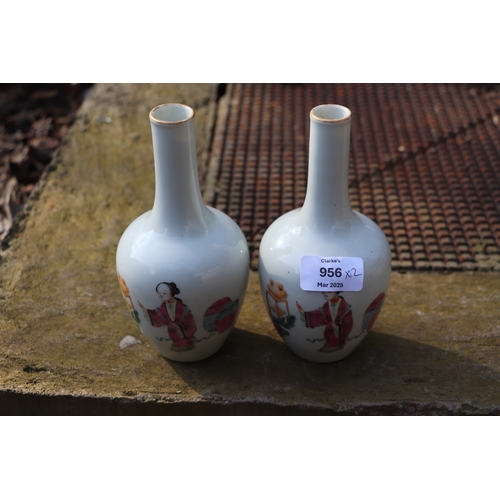 956 - A pair of Chinese famille rose bottle vases decorated with figures, 17cms high.