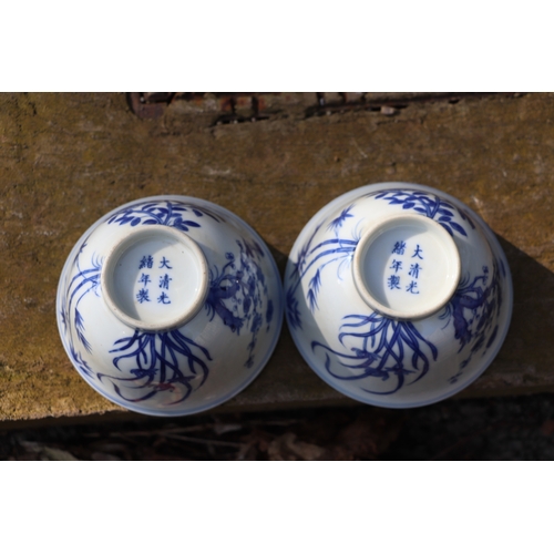 959 - A pair of Chinese blue & white footed bowls decorated with flowering foliage and bamboo with a drago... 