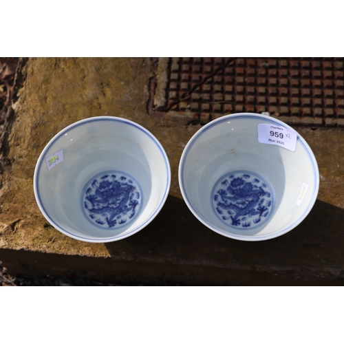 959 - A pair of Chinese blue & white footed bowls decorated with flowering foliage and bamboo with a drago... 