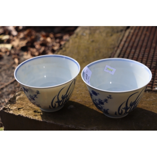 959 - A pair of Chinese blue & white footed bowls decorated with flowering foliage and bamboo with a drago... 