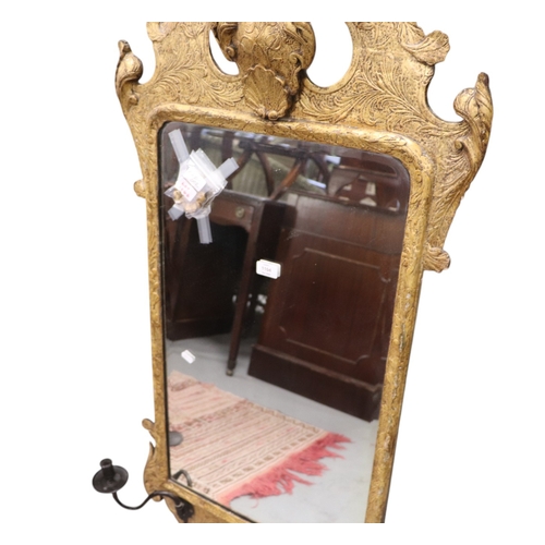 1104 - A 19th century giltwood wall mirror in the George II style, the later bevelled arched plate within a... 