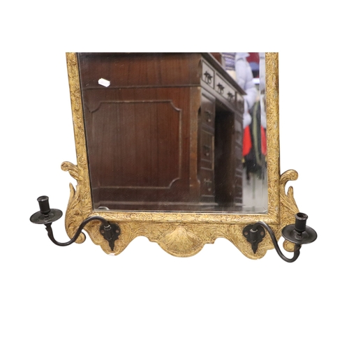 1104 - A 19th century giltwood wall mirror in the George II style, the later bevelled arched plate within a... 