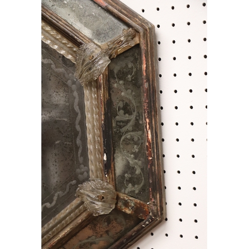 1064 - An 18th century cushion shaped mirror with ornate edge panels, overall 54 by 71cms.