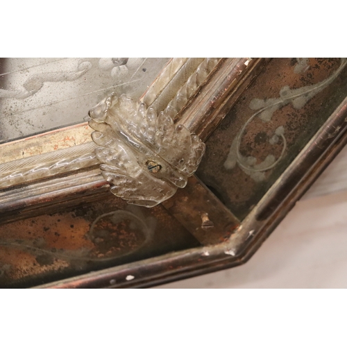 1064 - An 18th century cushion shaped mirror with ornate edge panels, overall 54 by 71cms.