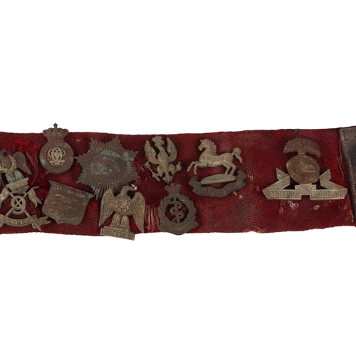 50 - A canvas stable belt of military cap badges pre and post WWI including Royal Scots Greys, Highland L... 