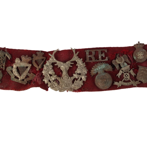 50 - A canvas stable belt of military cap badges pre and post WWI including Royal Scots Greys, Highland L... 