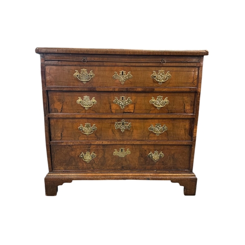 914 - An 18th century walnut chest with brushing slide above four graduated long drawers, on bracket feet,... 