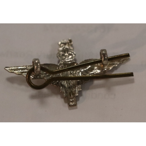 55 - A group of WWII cloth badges and cap badges to include Special Air Service cap badge and cloth badge... 