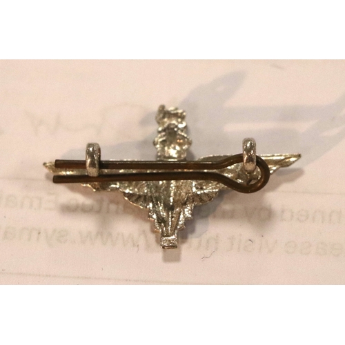 55 - A group of WWII cloth badges and cap badges to include Special Air Service cap badge and cloth badge... 