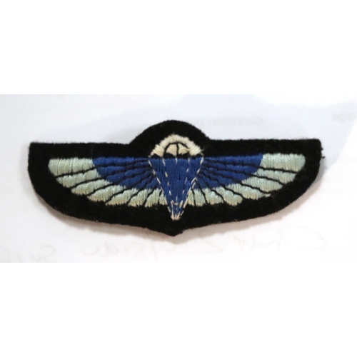 55 - A group of WWII cloth badges and cap badges to include Special Air Service cap badge and cloth badge... 