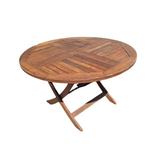 5 - A teak garden table, the circular top with collapsible base, 120cms diameter.