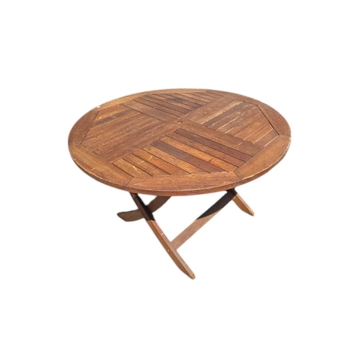 5 - A teak garden table, the circular top with collapsible base, 120cms diameter.
