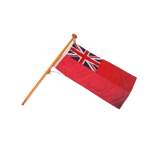 116 - A cotton Union Jack Ensign flag mounted on a pole. 90 by 44cm