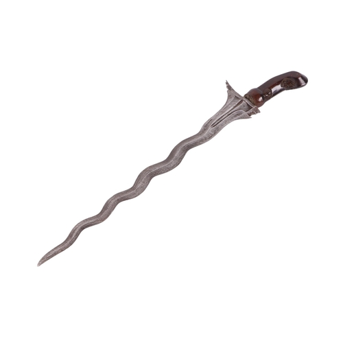 70 - A 19th century Javanese Kris with pamor wavy steel blade, carved hardwood handle and engraved brass ... 